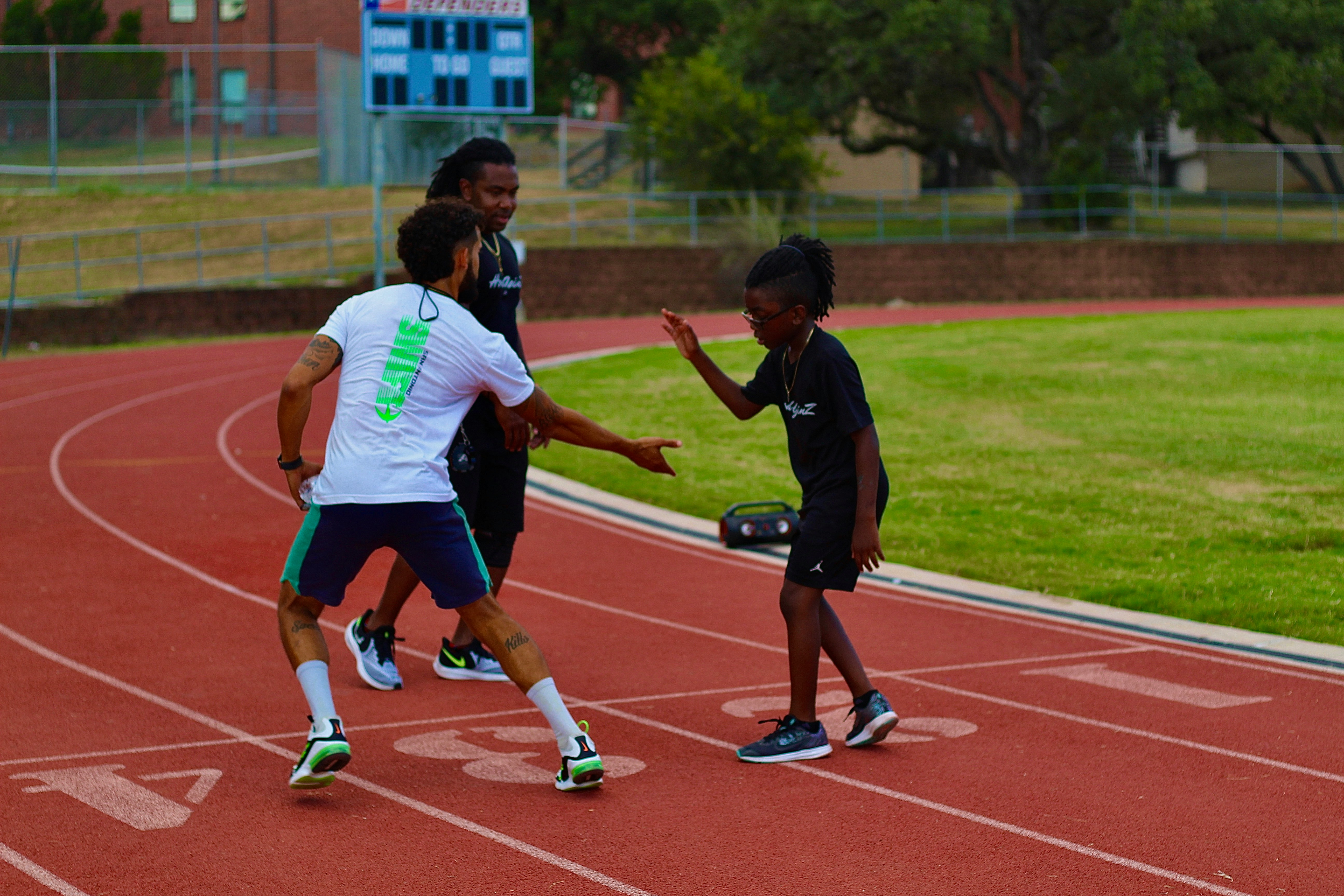 Coaches working with a young athlete on a track